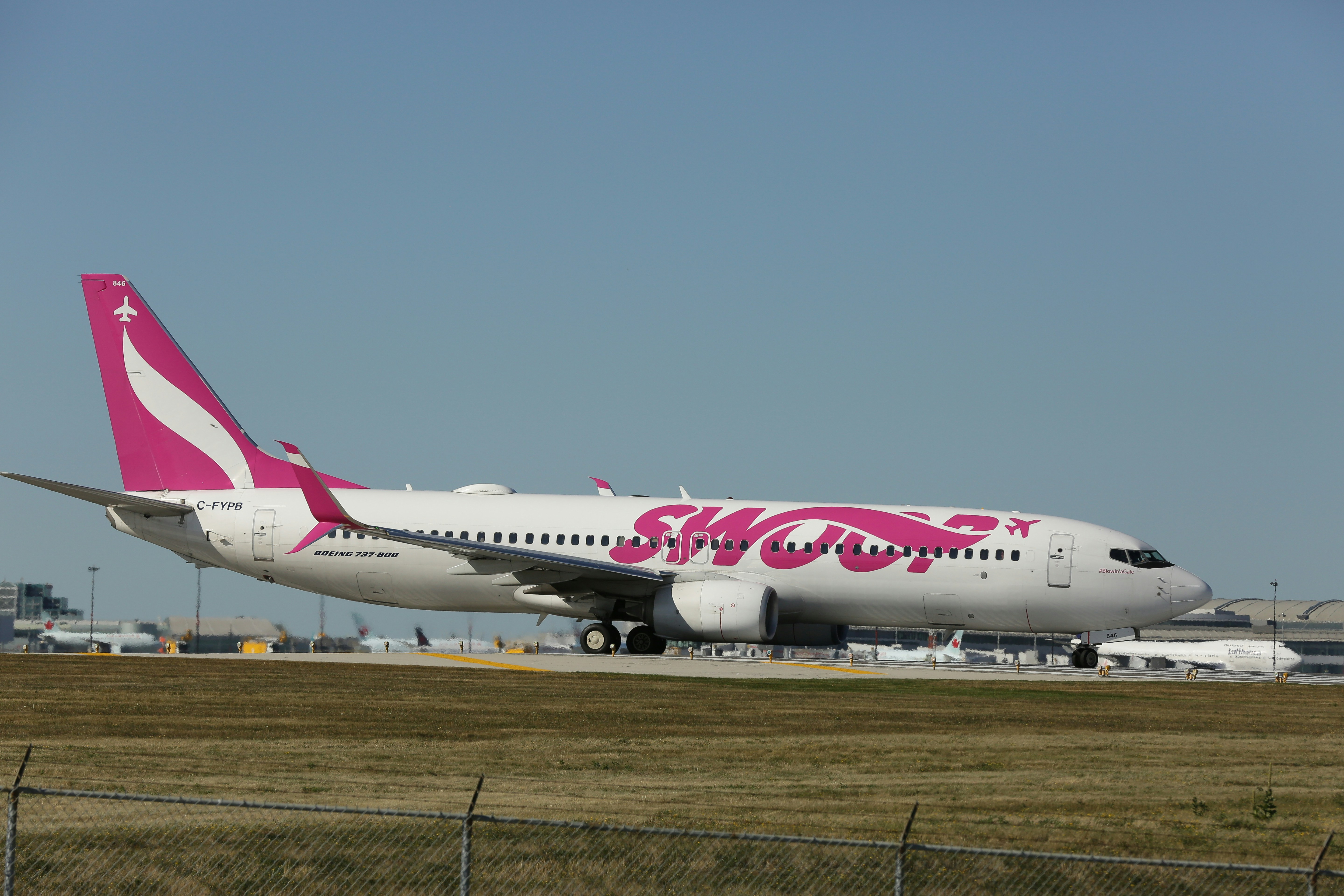 a pink and white airplane is on the runway, 