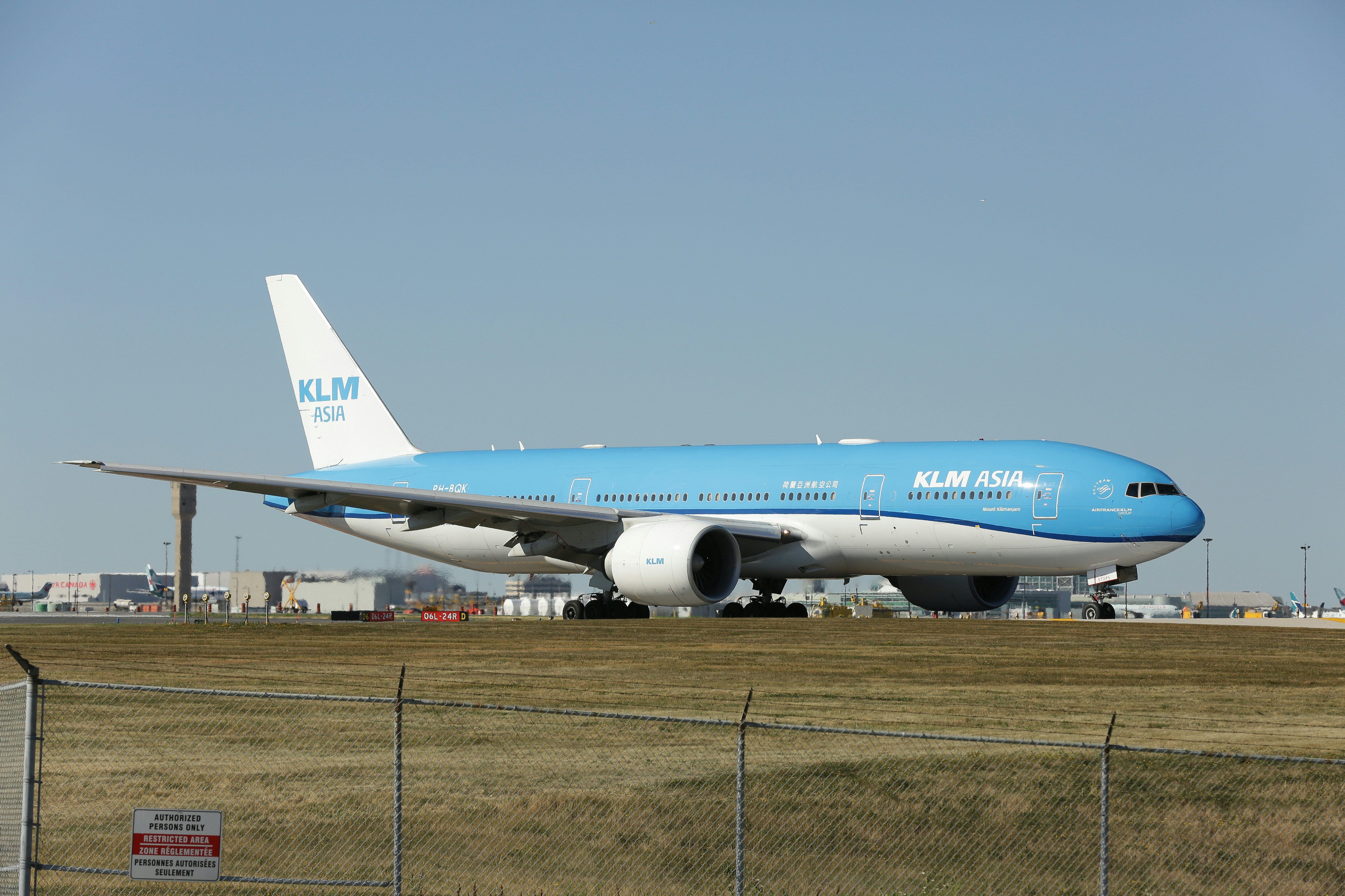 a large blue and white jetliner sitting on top of an airport runway