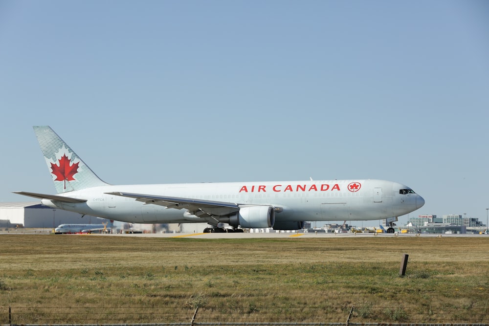 a large air canada jetliner sitting on top of an airport runway