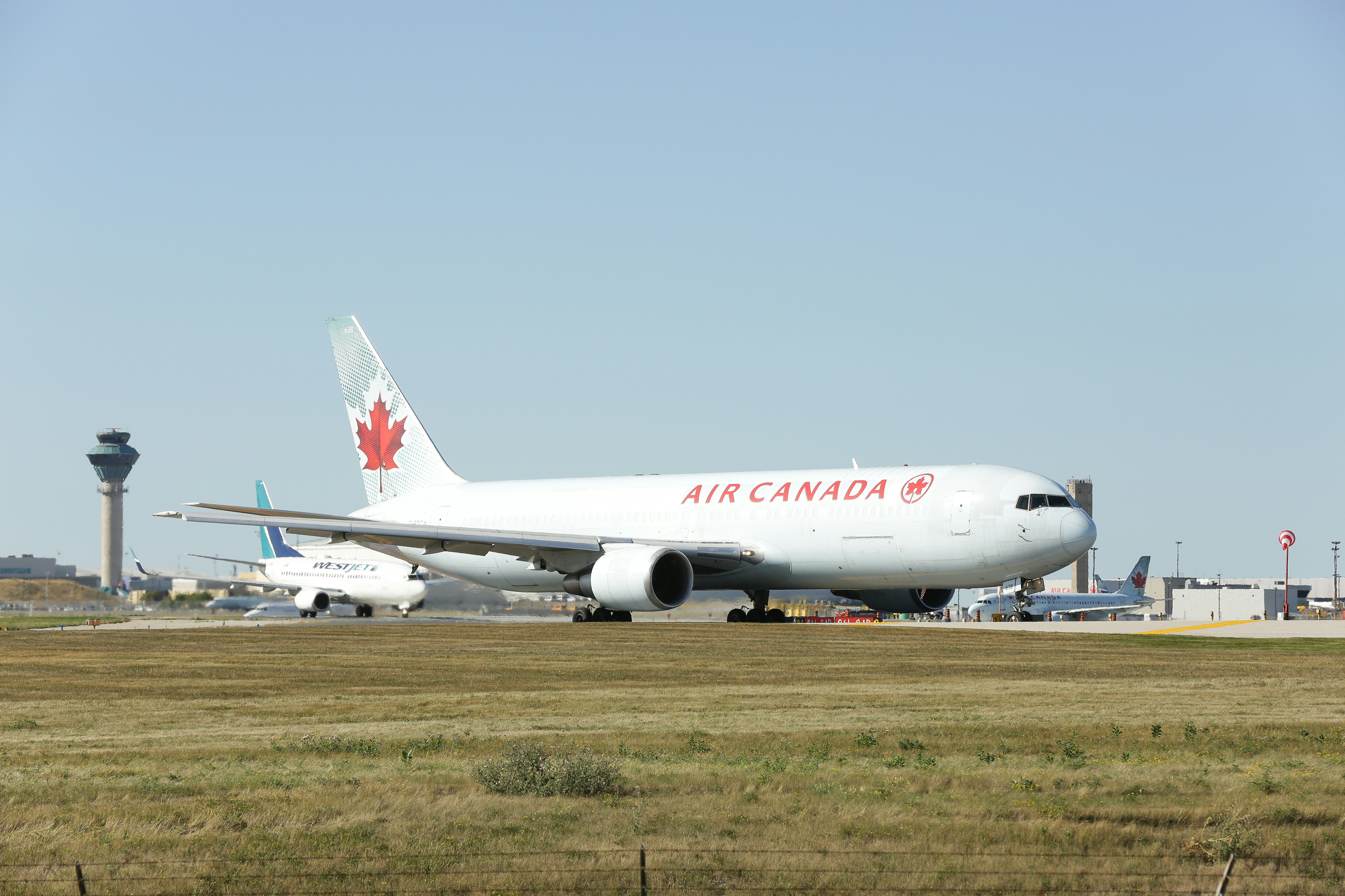 a large air canada jetliner sitting on top of an airport runway