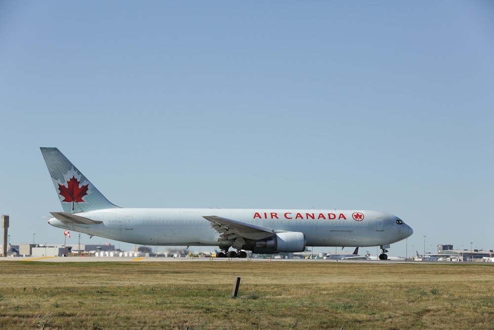 a large air canada jetliner sitting on top of an airport runway