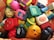 A collection of colorful cartoon figurines arranged randomly. The figures include a variety of characters with different facial expressions and accessories. The figurines are made of plastic and feature playful designs and bright colors.