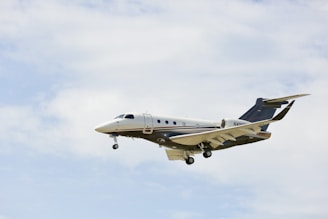 a small airplane flying through a cloudy blue sky