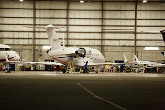 Technicians inspecting airplane engines in a hangar, highlighting maintenance procedures.