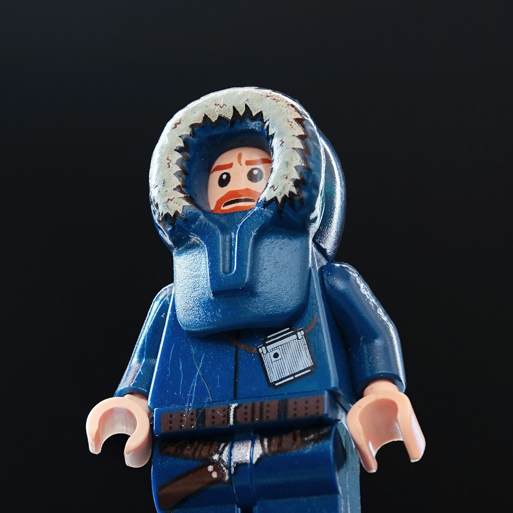 a lego figure wearing a blue coat and a hat