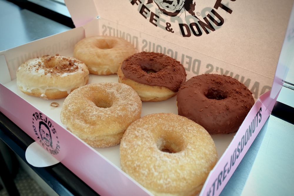 a box of donuts with chocolate frosting and sprinkles