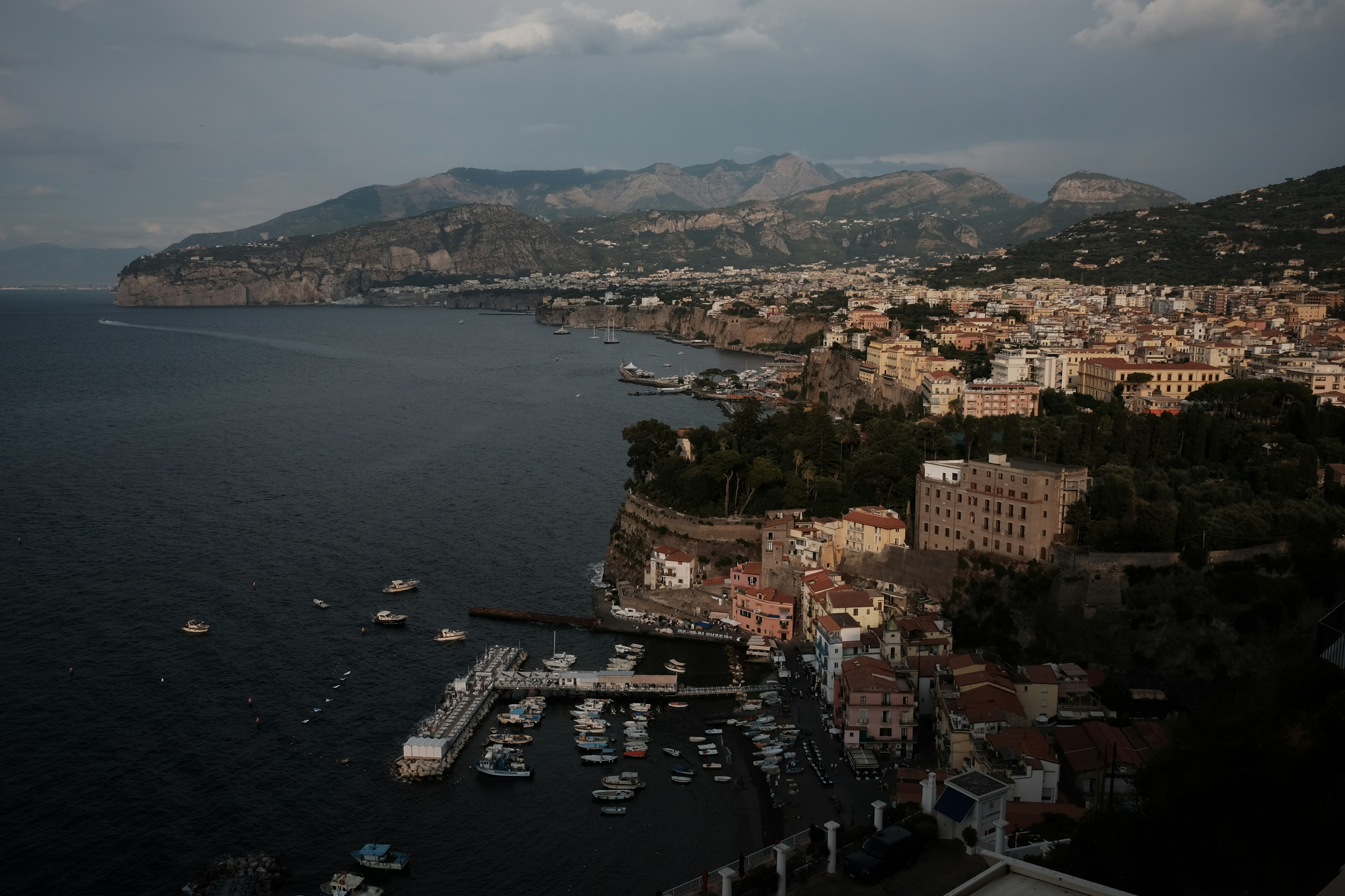 a harbor filled with lots of boats under a cloudy sky