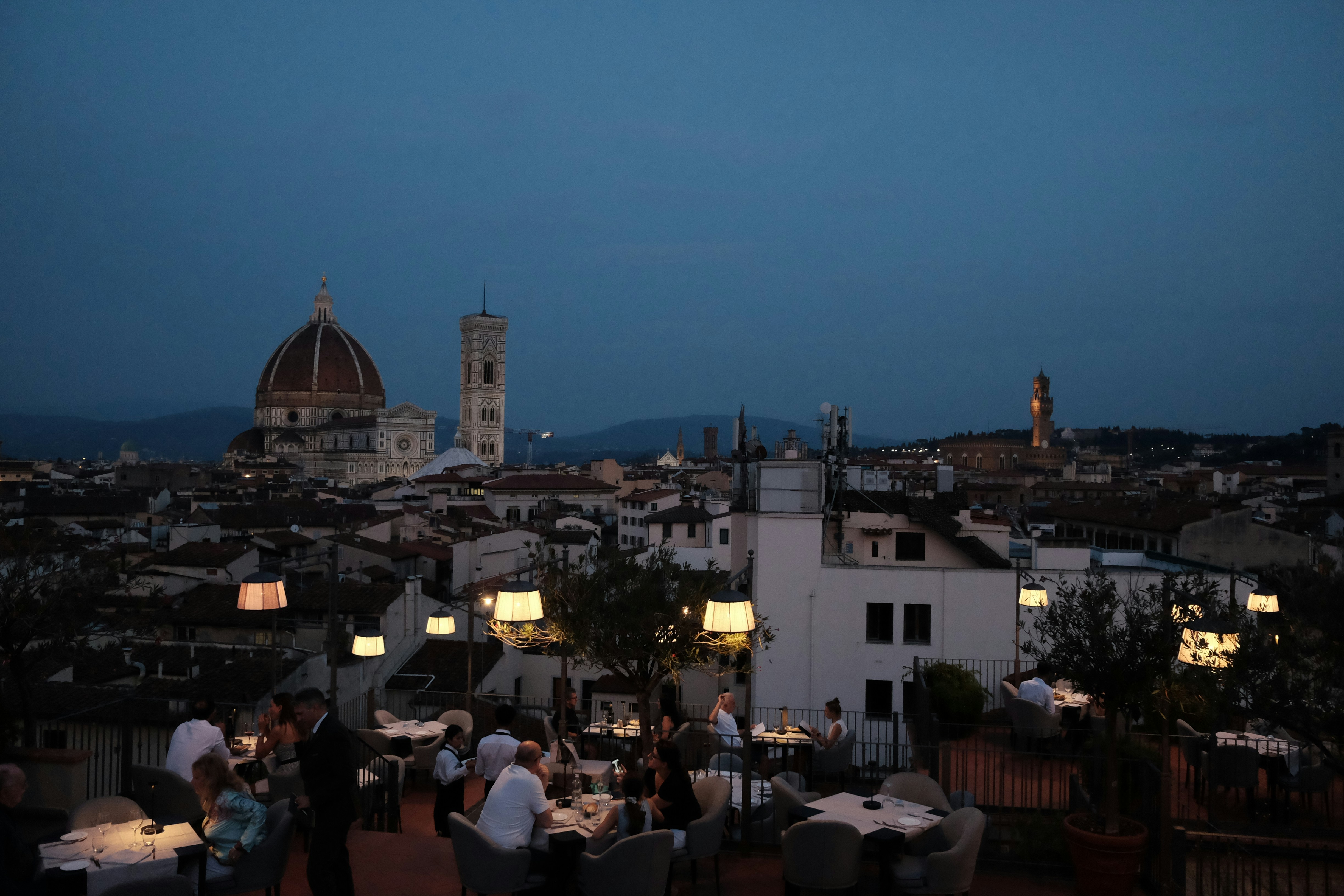 a group of people sitting at a table on top of a roof
