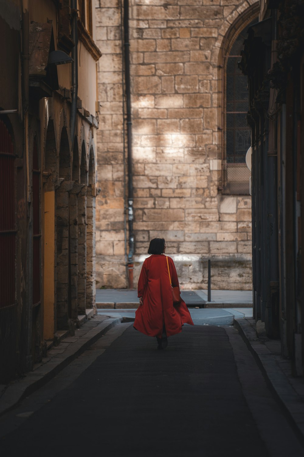 a person in a red robe walking down a street