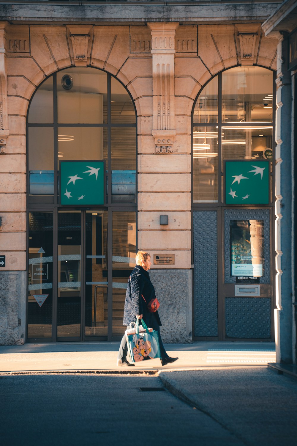 a woman walking down the street with a suitcase