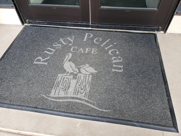 Durable custom mat placed at the entrance of a busy commercial building.