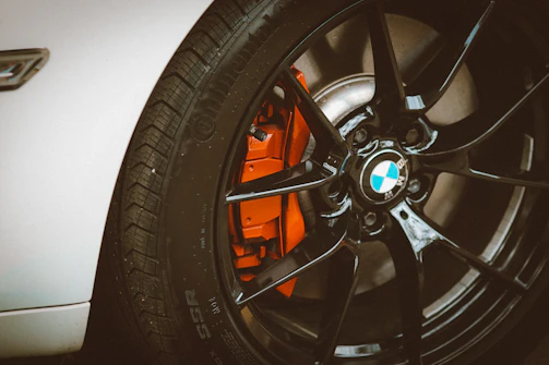 Powder-coated black alloy wheel with a glossy finish under bright lighting.