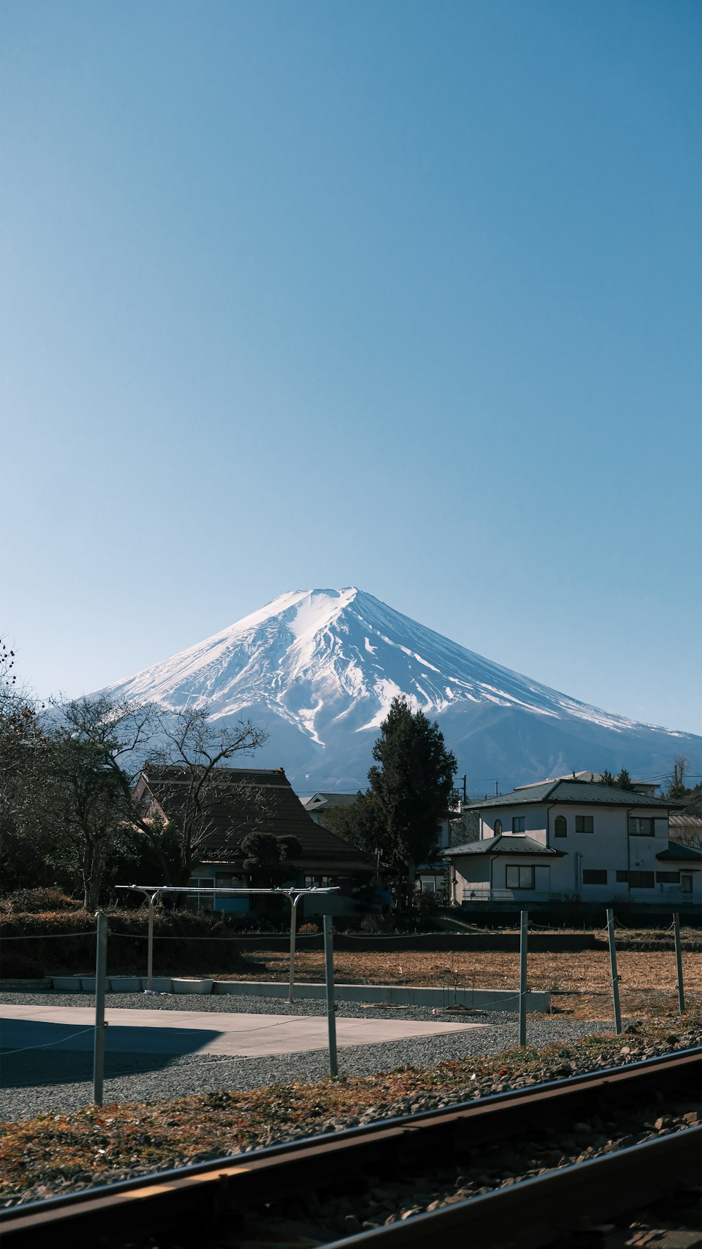 a view of a snow covered mountain from a train track