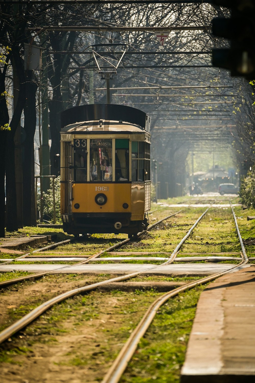 a yellow trolley car traveling down train tracks