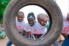 a group of men standing next to each other in front of a tire