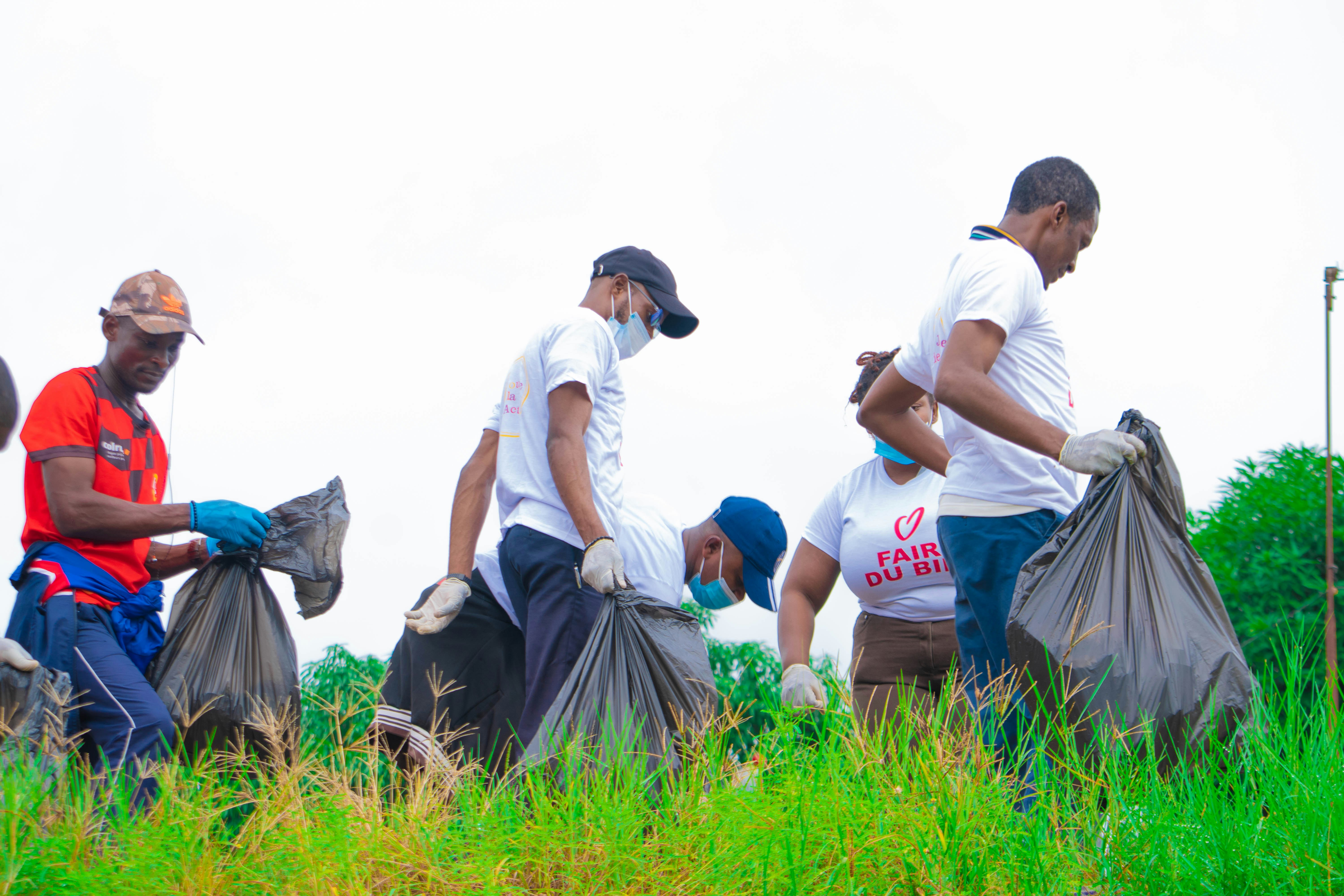 a group of men picking up trash in a field