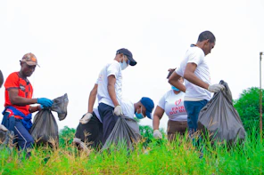 a group of men picking up trash in a field