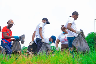 a group of men picking up trash in a field