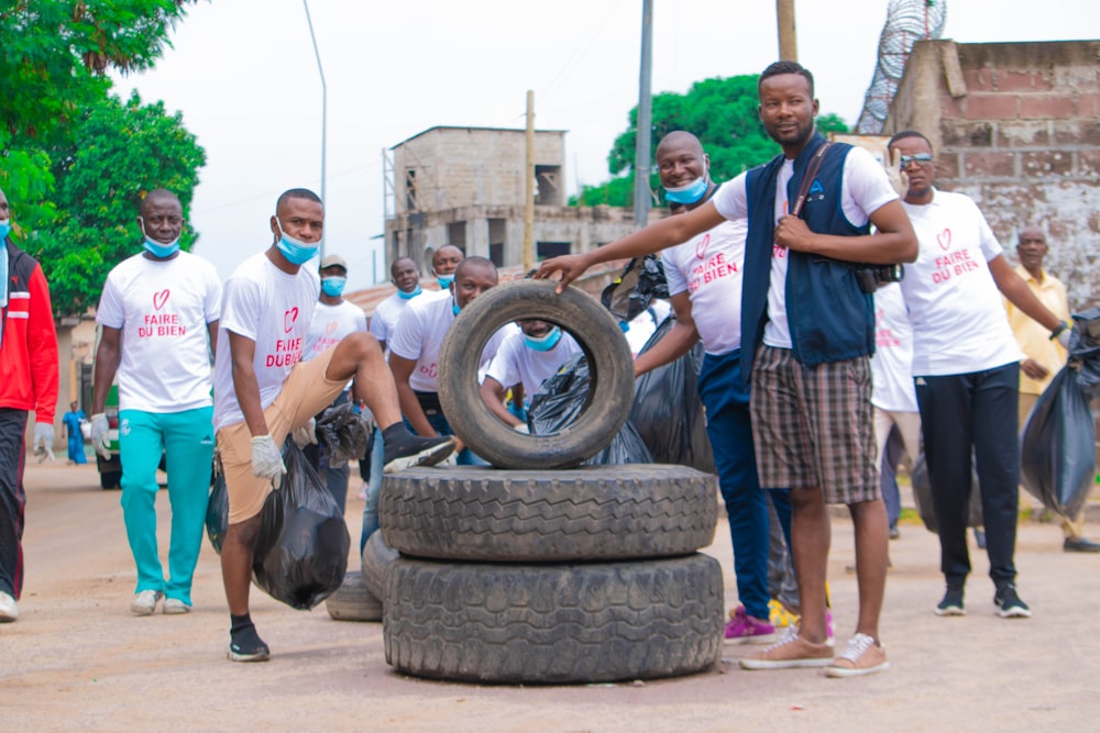 a group of people standing around a pile of tires