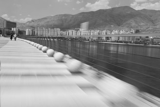 a black and white photo of a city with mountains in the background