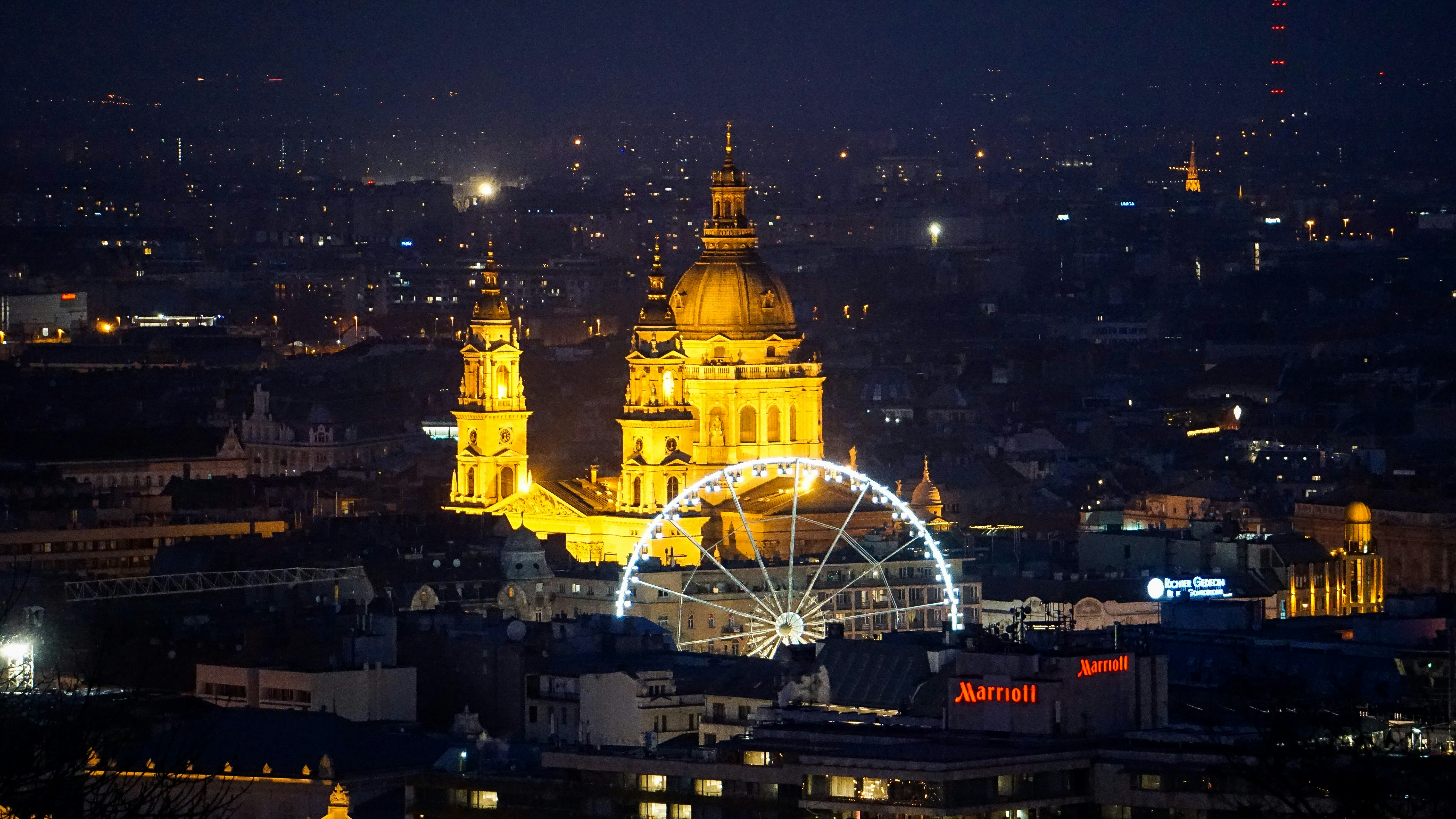 a city at night with a ferris wheel in the foreground