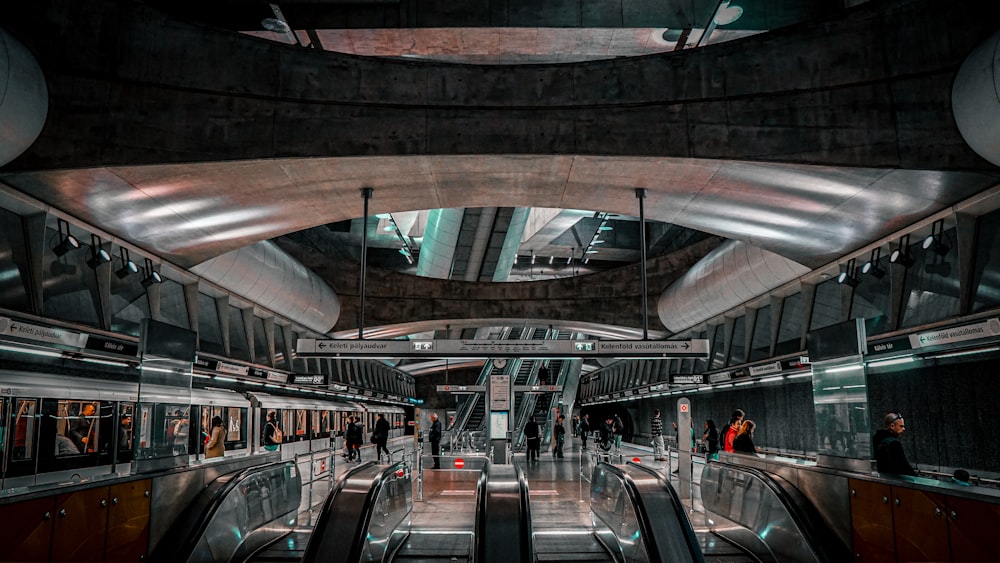 una escalera mecánica en una estación de metro con personas en las escaleras mecánicas