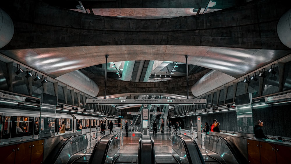 an escalator in a subway station with people on the escalators