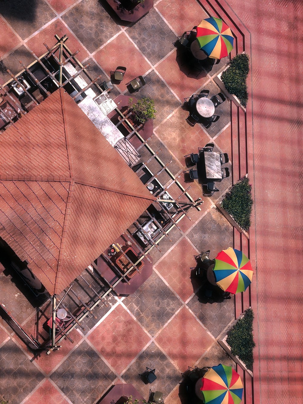 an overhead view of a patio with umbrellas and tables