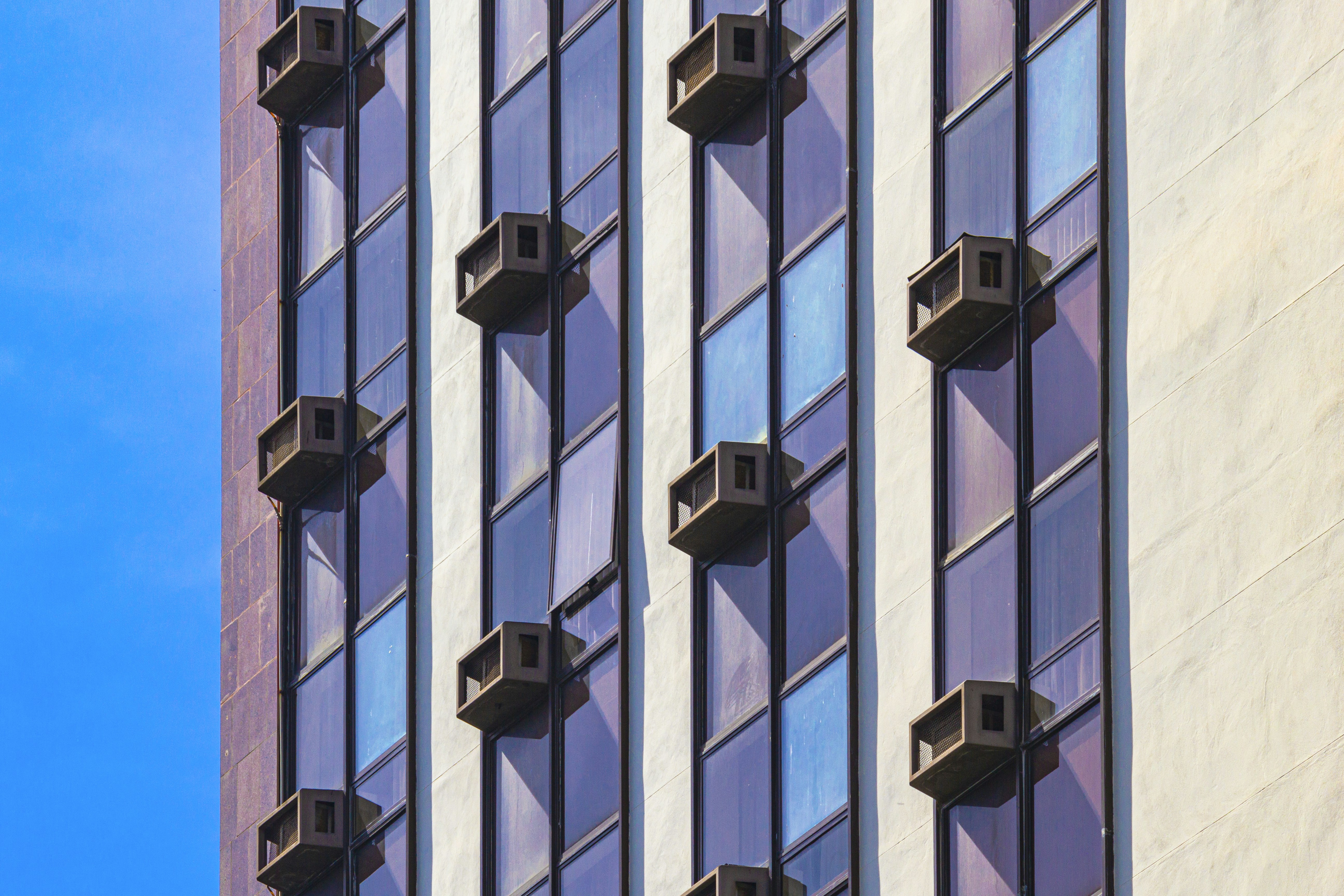 a tall building with lots of windows next to a blue sky