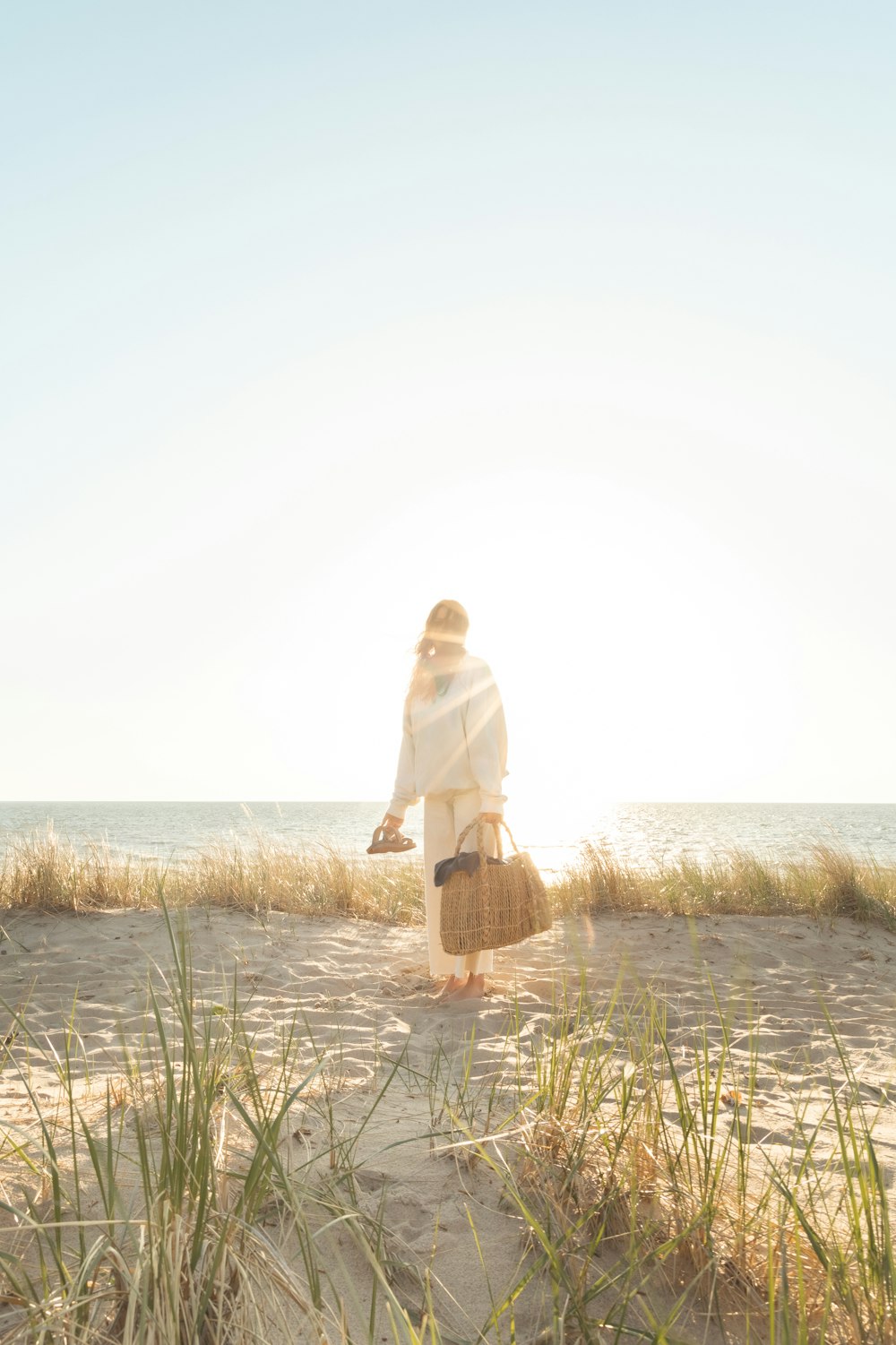 a woman standing on top of a sandy beach