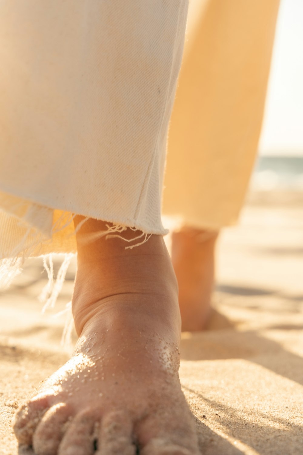 um close up dos pés de uma pessoa na areia