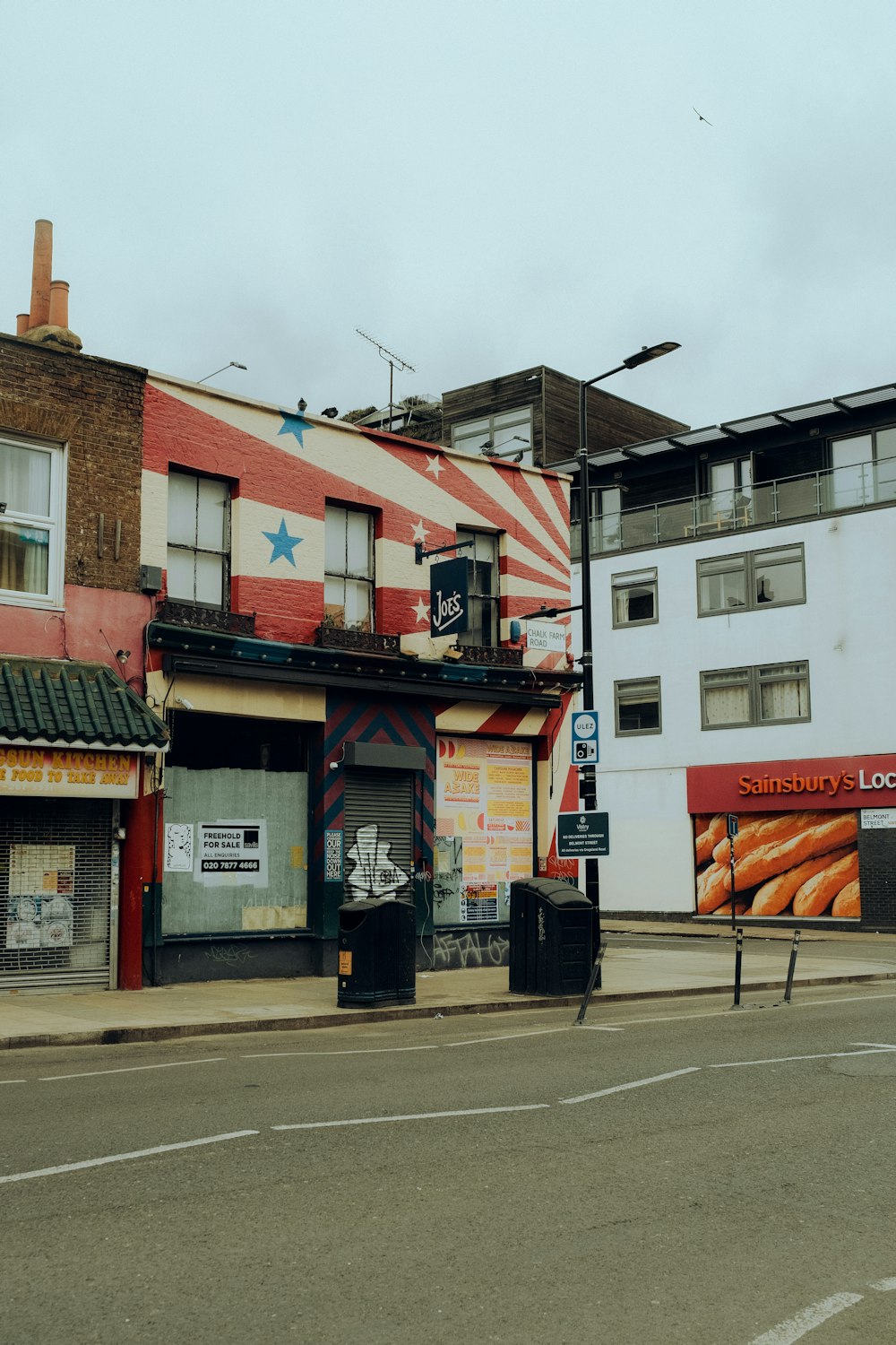 a street corner with a row of buildings in the background