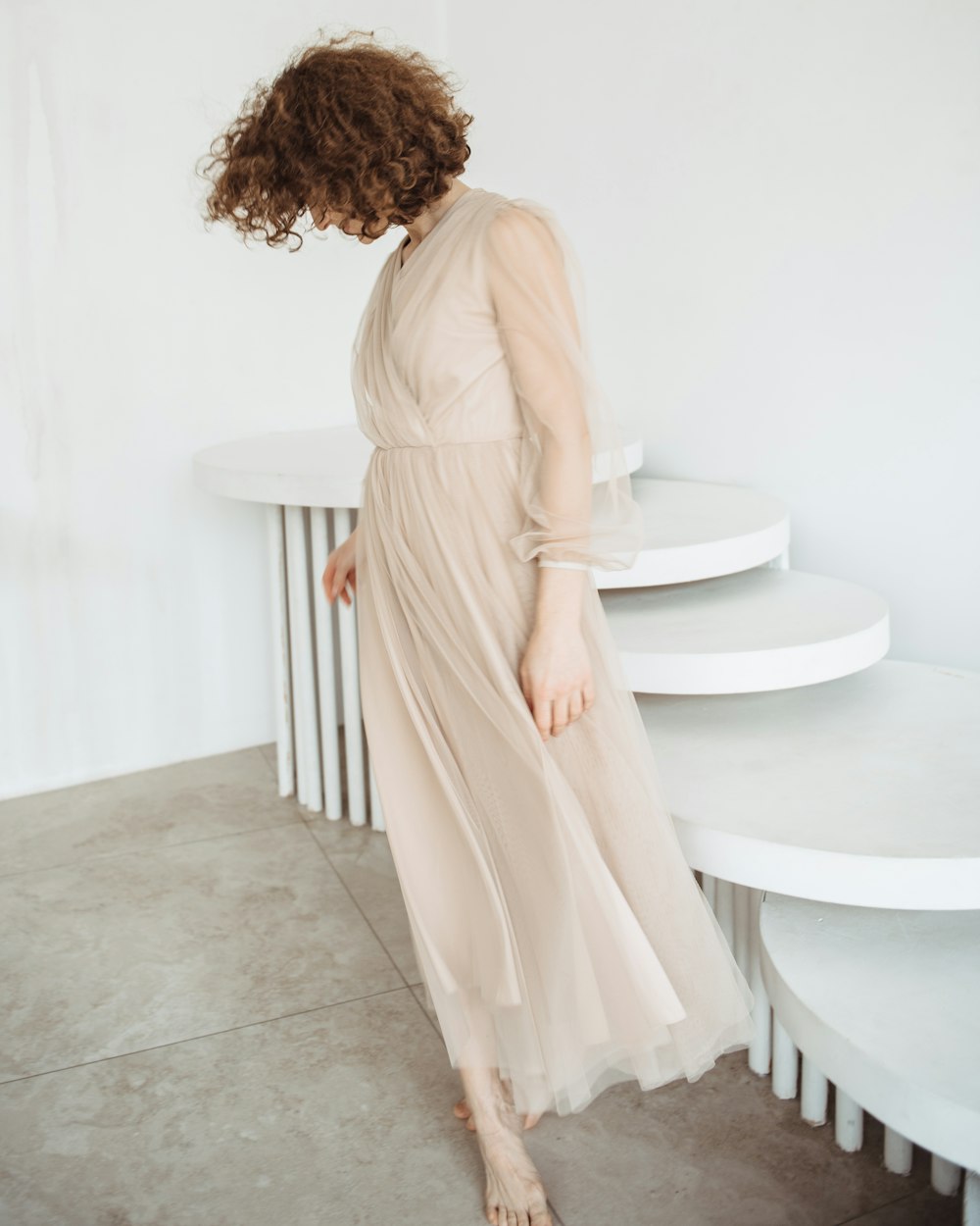 a woman standing in front of a white table