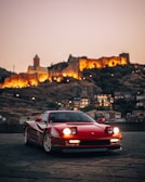a red sports car parked in front of a castle