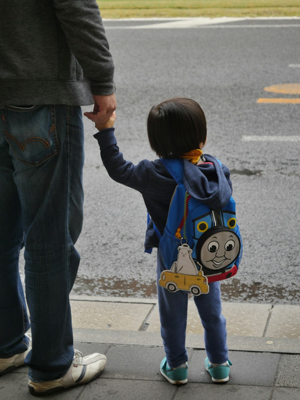 a little boy holding the hand of a man