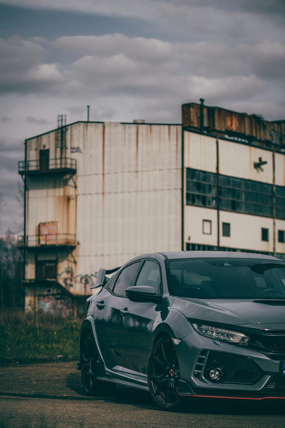 a grey car parked in front of a building