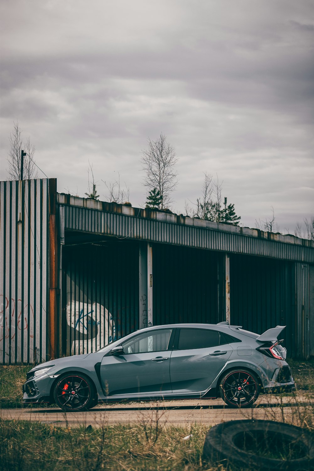 a grey car parked in front of a building