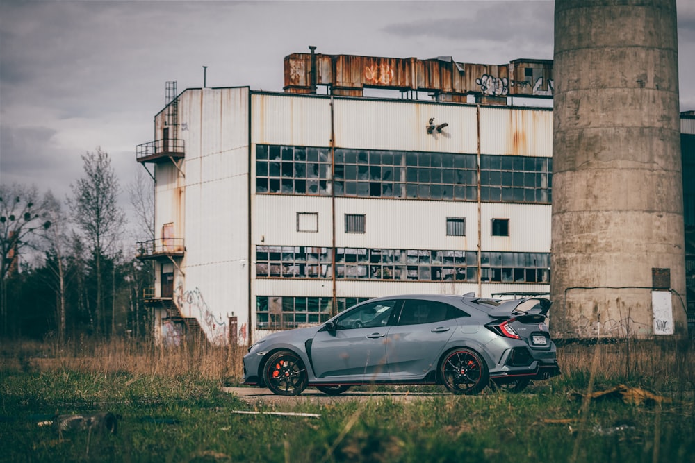 a grey car parked in front of a building