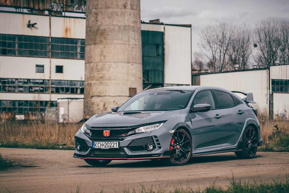 a grey car parked in front of a building