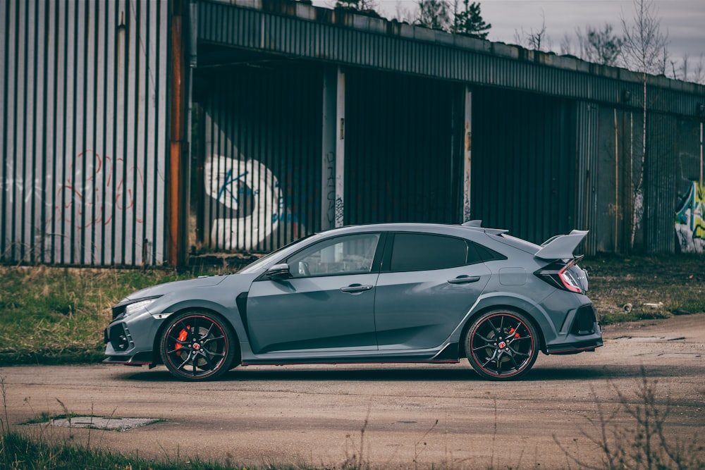 a grey car parked in front of a building