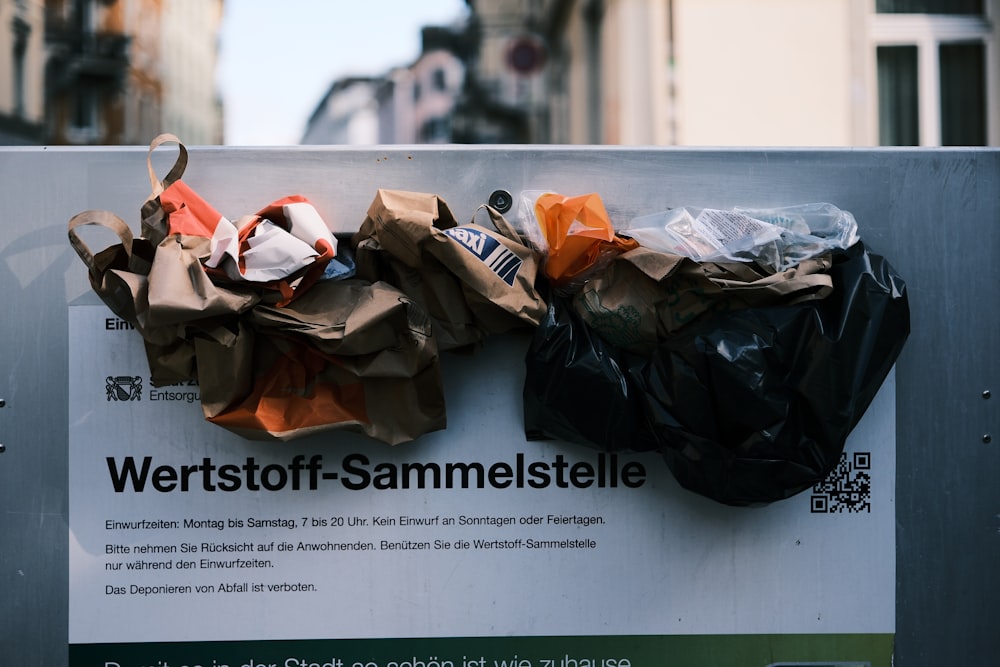 a bunch of bags sitting on top of a sign