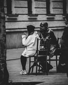 a couple of people sitting on top of a wooden chair