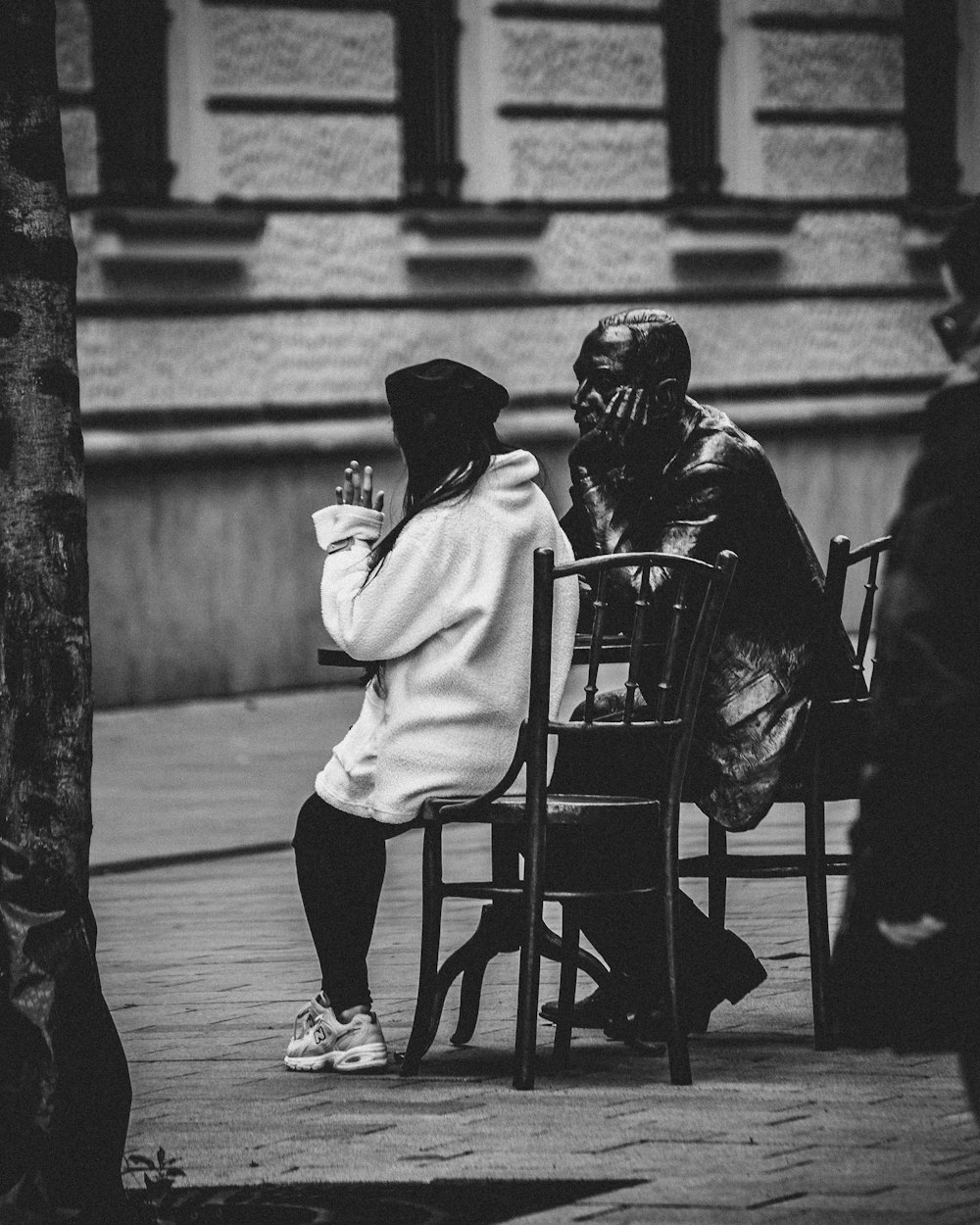 a couple of people sitting on top of a wooden chair