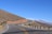 A scenic mountain road winding through the Pyrenees under a clear blue sky.