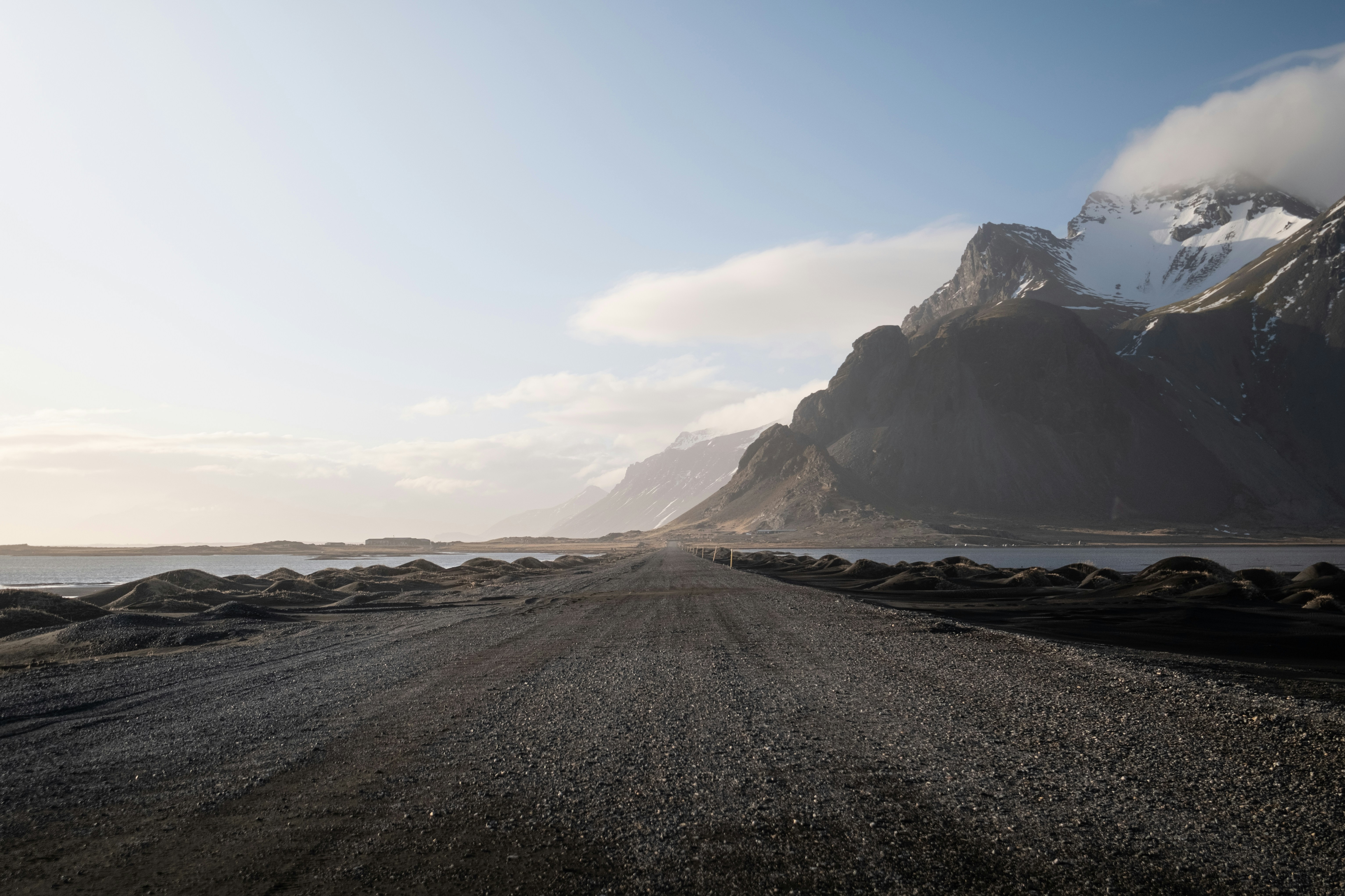 a dirt road with a mountain in the background