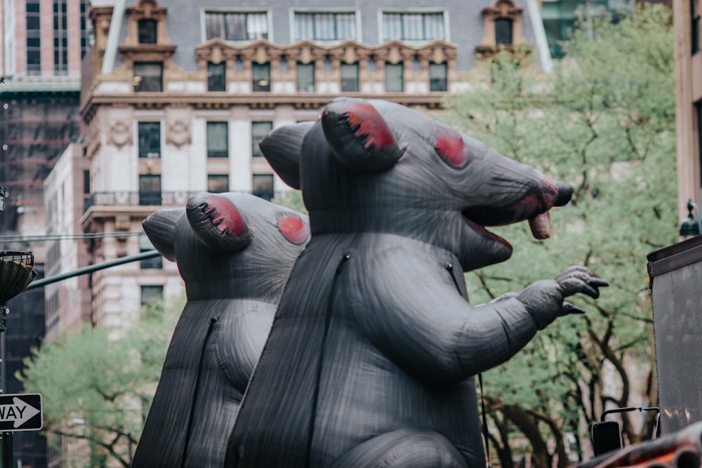 Une grande statue de rat gonflable dans une rue de la ville