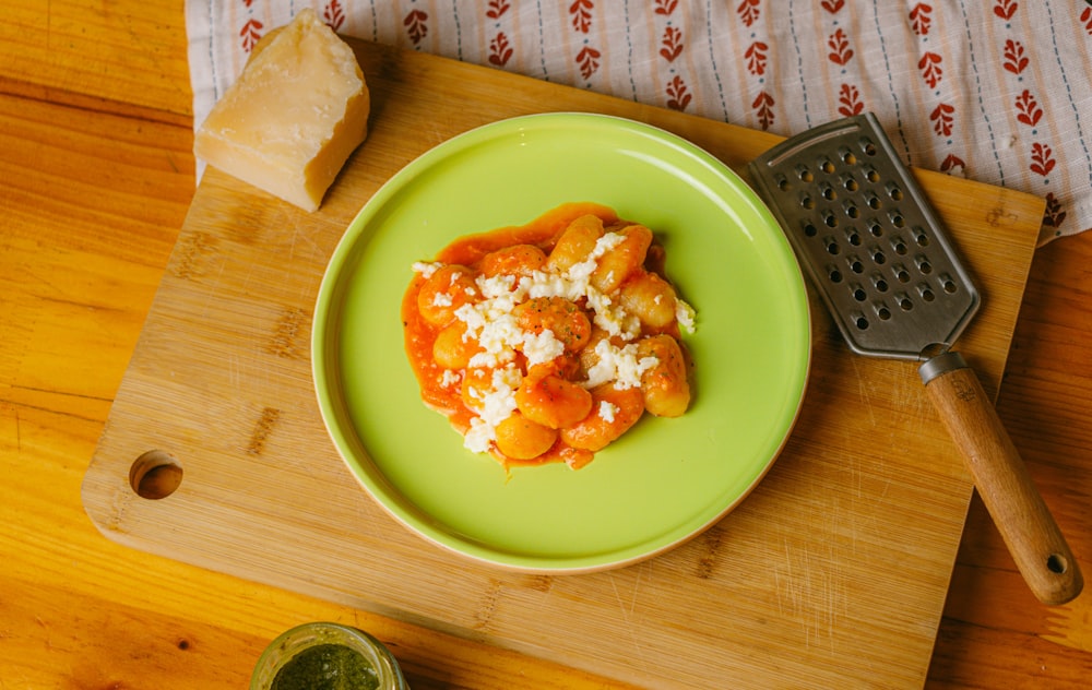 a green plate topped with food next to a grater