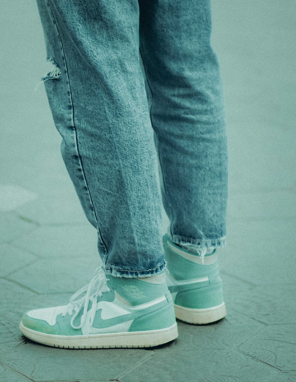 a person standing on a sidewalk with a skateboard