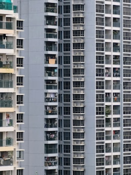 Close-up of a balcony screen installed on a sunny day with urban buildings in the background.