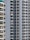 A close-up view of several high-rise apartment buildings with numerous balconies, each adorned with railings. Some balconies have laundry hanging, adding a touch of everyday life. Air conditioning units are visible on the outer walls, reflecting an urban residential setting.